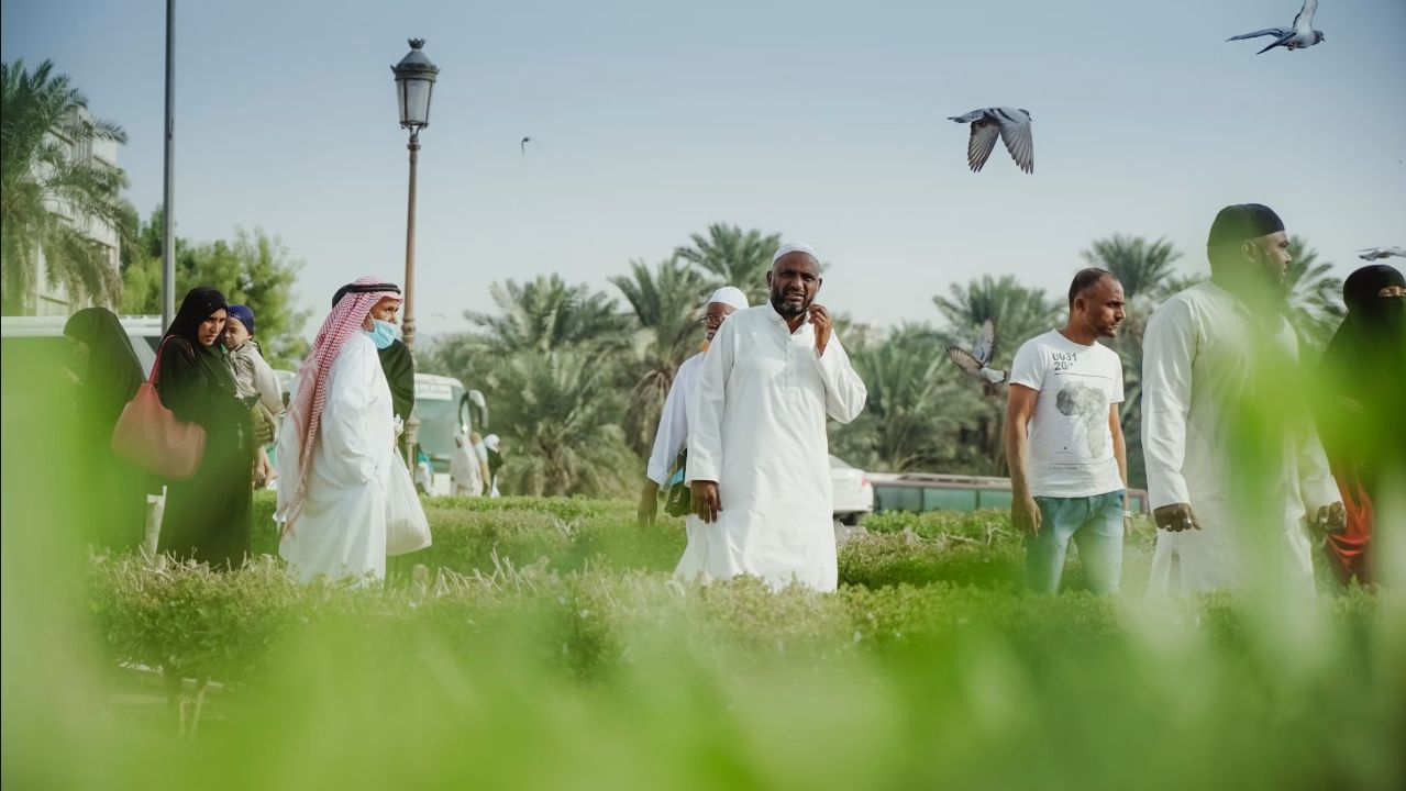 أشخاص يمشون في مساحة خضراء دافئة